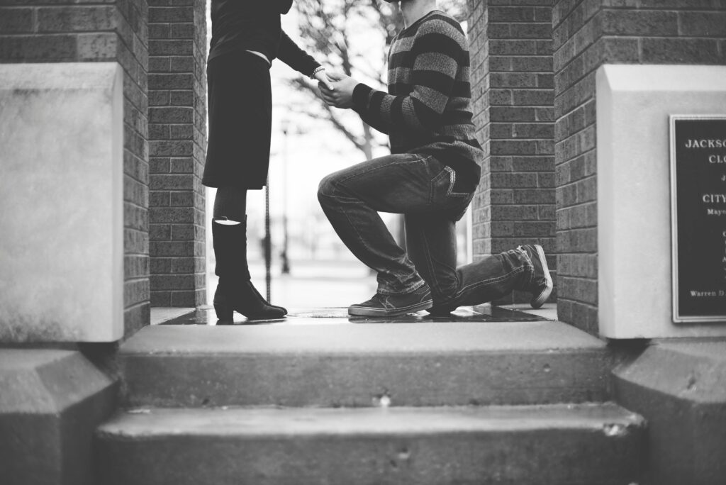 Man kneeling in front of a woman, symbolizing decision-making in software development.